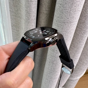 Close-up of textured black rubber strap and silver polygonal casing of the men's watch