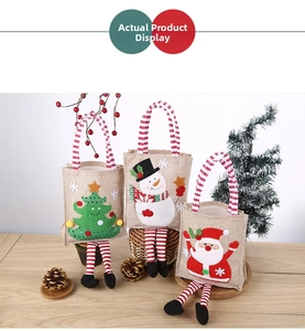 Detailed view of three burlap Christmas gift bags with long legs and classic festive icons