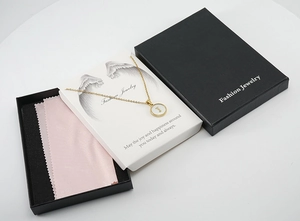 Coffret cadeau avec collier doré initiale J dans sa boîte noire et son chiffon