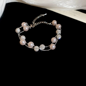 Detailed macro view of French style double-layered pearl necklace with silver lobster clasp