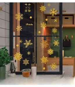 Detail of golden glitter snowflake and star static window stickers on a glass door