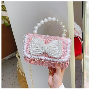 Détail du sac enfant en laine rose avec nœud en perles et bandoulière dorée