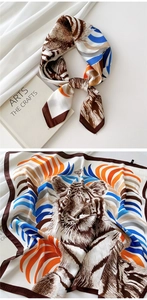 Detail of artistic tiger print silk scarf in orange and blue with art book setting