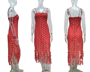 Detailed view of red midi dress featuring laser-cut polka dots and tassel hem details