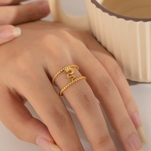 Close-up of a double-layered golden snake ring with heart detail on a female hand