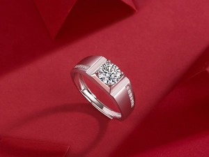 Close-up of men's silver moissanite ring with round main stone and side diamonds