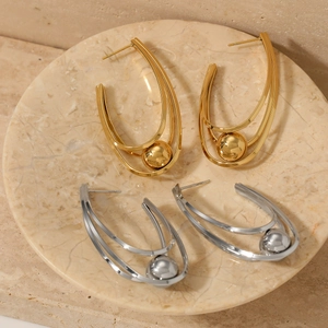 U-shaped hollow ball multi-layer earrings in gold and silver finish on marble tray