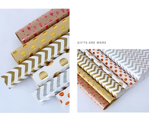Detail of assorted gold and silver striped gift wrapping paper rolls with metallic finish
