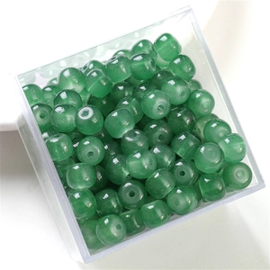 Macro shot of green round glass jelly jade beads in a box for DIY jewelry making