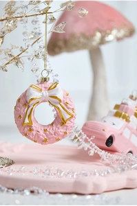 Detail of pink Christmas wreath ornament with woven texture and gold bead accents