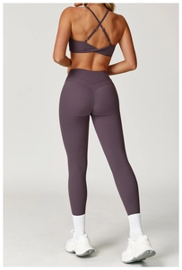 Dettaglio del reggiseno yoga incrociato e leggings a vita alta in viola polvere