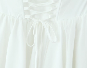 Detail eines weißen Netzkleids mit Rückenschnürung und plissierter Chiffon-Textur