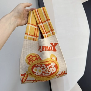 Detailed texture of knitted tote bag with !Yummy embroidery and checkered strap