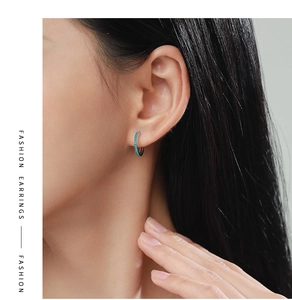 Close-up of model wearing 925 silver hoop earrings with turquoise pavé setting