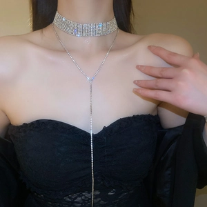 Détail d'un ensemble de colliers à franges en strass argentés portés par un modèle