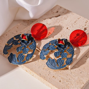 Detail of vintage flower earrings with red resin studs and blue metal floral pendants
