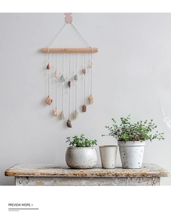 Detail of bohemian wall hanging featuring natural stones on a rustic wood branch