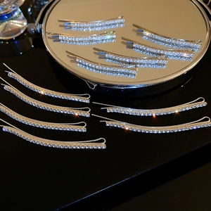 Set of sparkling rhinestone hair clips in silver finish shown on a reflective surface