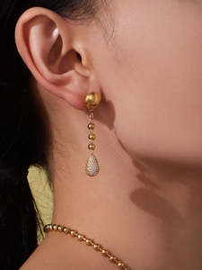 Détail des boucles d'oreilles pendantes plaquées or 18k avec pendentif en zircone