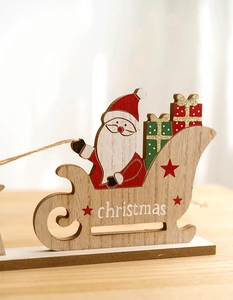 Close-up of wooden Christmas sleigh with Santa, glitter details, and festive text
