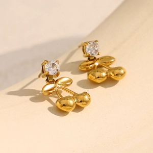 Vue macro de boucles d'oreilles cerises dorées 18K ornées de zircons ronds brillants