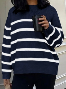 Detail of navy blue striped knit sweater worn by model in a cozy indoor setting
