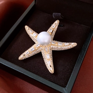 Detailed shot of 14K gold plated starfish brooch with white pearl and sparkling crystals
