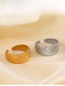 Detailansicht der gold- und silbernen Ringe mit Rautenmuster auf weichem Seidenstoff