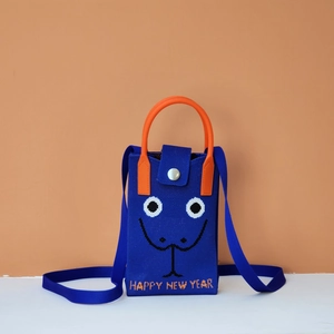 Detailed knit texture of a blue vertical mobile bag with orange ring handle and eyes