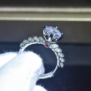 Vista macro laterale di anello in argento con pietra tonda e fascia con pavé di diamanti