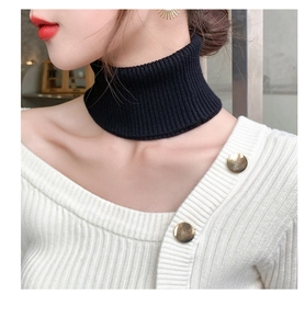 Detail of black ribbed knit cashmere neck warmer styled as a mock collar with cardigan