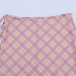 Détail de la jupe en résille à carreaux violets et jaunes avec nouage latéral