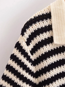 Dettaglio della maglia grossa e del colletto bianco sul maglione a righe bianche e nere
