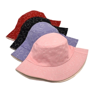 Motifs floraux matelassés sur des bobs en coton colorés avec détails de broderie précis