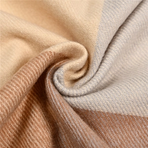 Macro view of soft cashmere-like fabric with warm beige and grey plaid twill texture