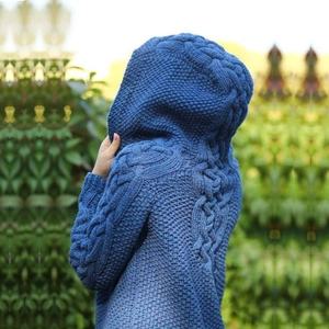 Dettaglio del cappuccio in maglia a trecce blu scuro con trama a nido d'ape e lana spessa