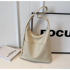 Macro shot of off-white tote bag with lychee grain texture and front pockets