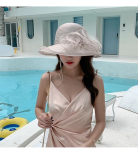 Close-up of beige summer sun hat with large 3D mesh flower detail in a poolside setting