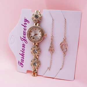 Elegant rose gold quartz watch and bracelet set with heart charms on pink background