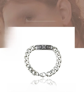 Close-up of vintage silver cuban chain bracelet featuring a sunburst engraved square plate