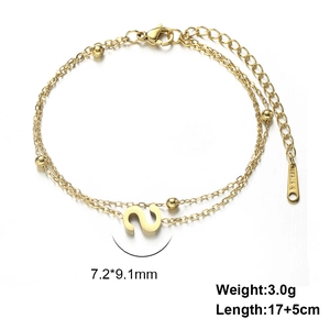 Detail of gold double-layer stainless steel bracelet with S pendant and metal beads
