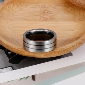 Macro detail of men's matte titanium ring featuring three black parallel groove lines