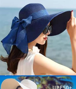 Dettaglio di cappello di paglia a tesa larga con grande fiocco e protezione UPF50+