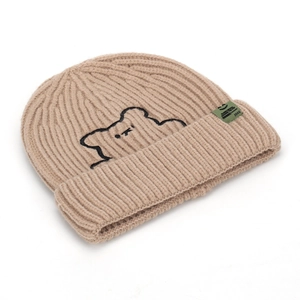 Beige knit beanie featuring embroidered bear and woven label in a ribbed texture