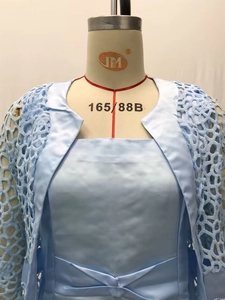 Détail de la robe en satin bleu clair avec cardigan en dentelle au crochet assorti sur mannequin