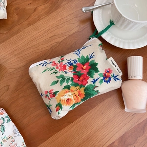 Detailed close-up of floral cotton pouch with zip closure and minimalist brand label