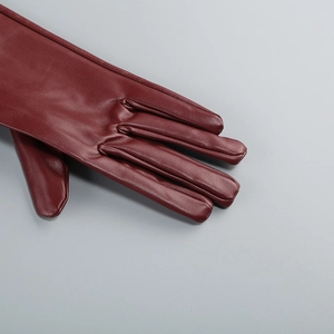 Detail of burgundy leather glove fingers with fine stitching and natural texture