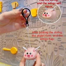 Pink flying pig keychain with pull-string mechanism and moving mechanical wings
