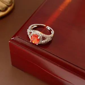 Sparkling silver open ring with oval orange zircon and micro-set crystals on a gift box
