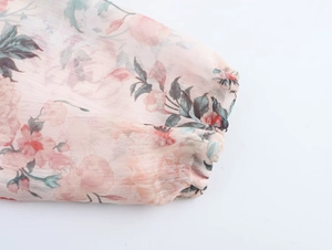 Detail shot of chiffon floral dress sleeve featuring elastic ruffled cuffs and pink print